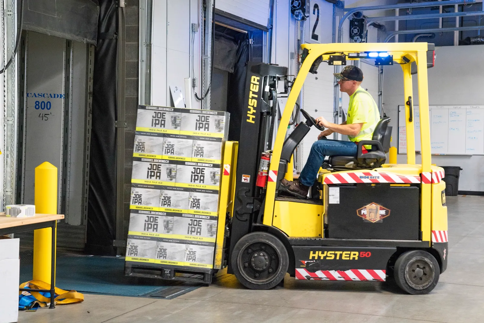 Used Hyster 50 forklift loading pallets at a warehouse dock, for sale in Baltimore, MD